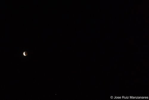 Luna eclipsada junto a un
